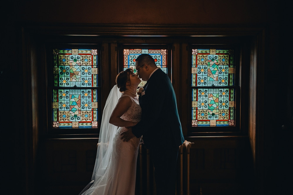 Bride and groom portrait with stained glass at Knowlton Mansion